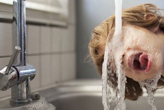 Trinkbrunnen Trinkwasser Junge trinkt Wasser bei Wasserleitung